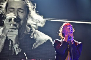 Brandon Boyd sings along to his band's song, "Pardon Me," as his video self is projected on the screen behind him.