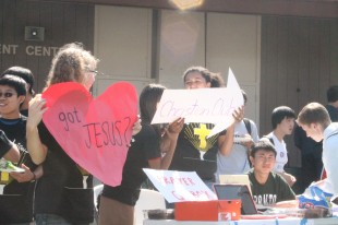 Ilana Baer and Micayla Brewster of the Agape Christian Club draw in members with their colorful signage.  Along with the Jewish Student Union, these clubs were the only religious clubs among over 55 club offerings.