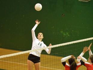 Outside hitter Becca Raffel rises above the net for a hit in Paly's straight-set victory over crosstown rival Gunn High School.  Photo by Matt Ersted.