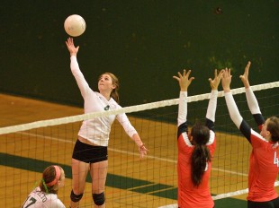 Shelby Knowles tips the ball over the net and two Gunn High School blockers in Paly's straight-set victory over its crosstown rival.  Photo by Matt Ersted.