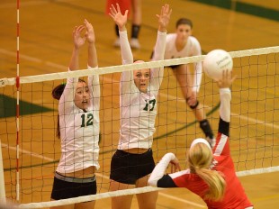 Jade Schoenberg (12) and Lauren Kerr (17) rise above the net to block a spike from a Gunn High School hitter in the crosstown matchup between Paly and the Titans Tuesday night.  Photo by Matt Ersted.