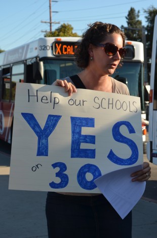 Paly teacher Rachael Kaci holds up a sign urging for people to vote Yes on Prop 30 at the demonstration yesterday. Photo by Cathy Rong.