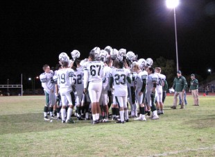 The Vikings raise their helmets in unison during a huddle after defeating the Wilcox Chargers 38-12. senior tight end De’Antay Williams led the way with two receiving touchdowns. [Credit: Jared Schwartz]