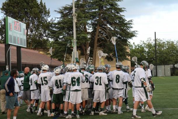 The Paly varsity boys lacrosse team meets in a huddle before the game. Photo by Parker Devine.