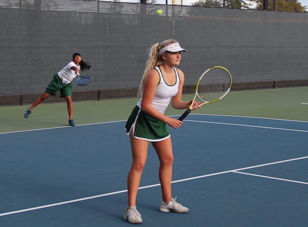 Sophomore Anuva Banwasi serves the ball in a doubles match with graduated senior and captain Meredith Cummings. The undefeated Vikings went on to win the game 4-3 on senior night. Photo: Ethan Kao.