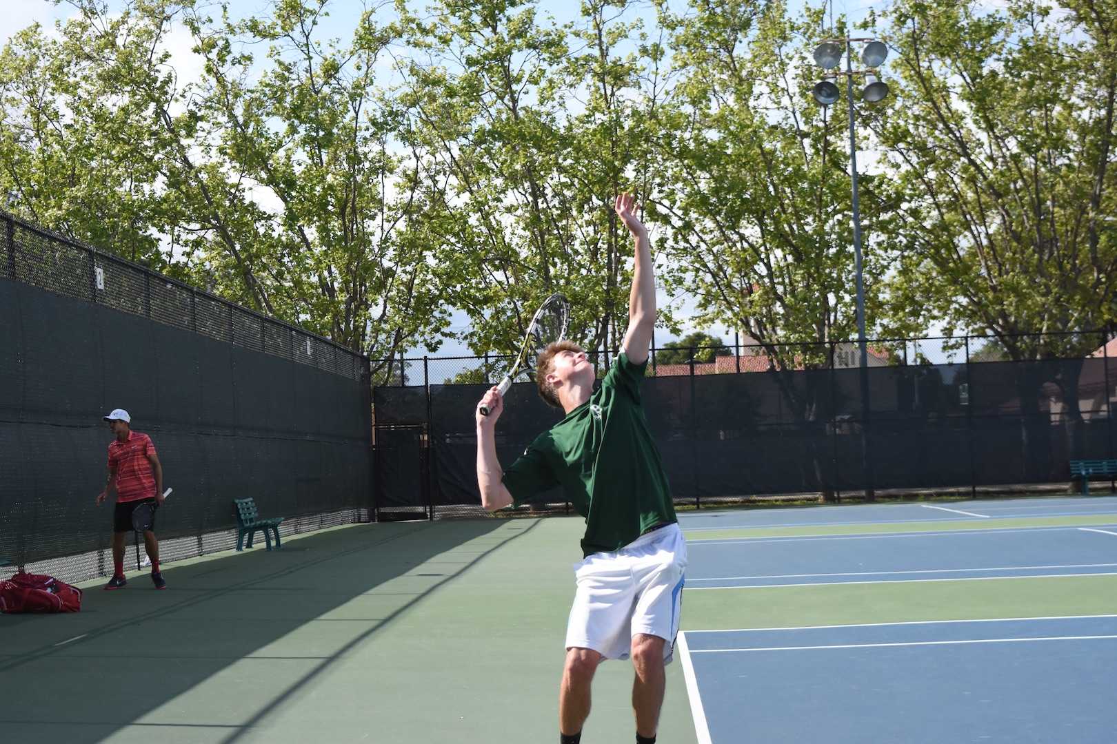 Senior Adrian Tompert serves a ball to his opponent.