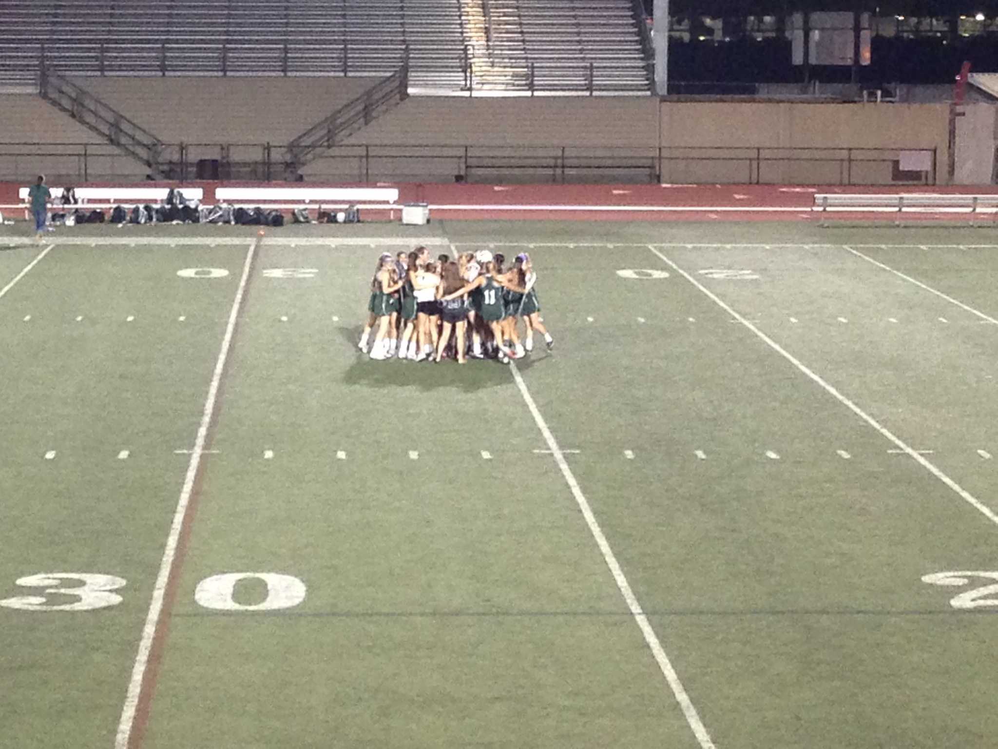 The Palo Alto girls' lacrosse team huddles after their win against St. Francis. Photo by Molly Fogarty.