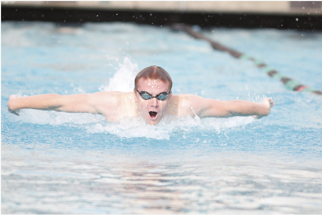 Senior and boys captain, Ryan Drover, swims butterfly during practice. The boys' and girls' swim teams have been training hard and will compete at league championships this week. Photo by George Lu.