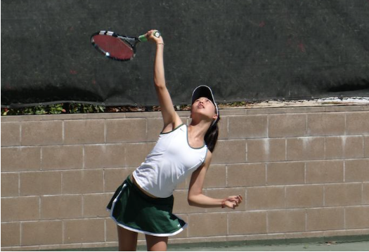 Senior co-captain Kelsey Wang serves the ball during practice. According to Wang, the team's first match will be today and the girls hope to start the season strong with a win. Photo courtesy of Wang.