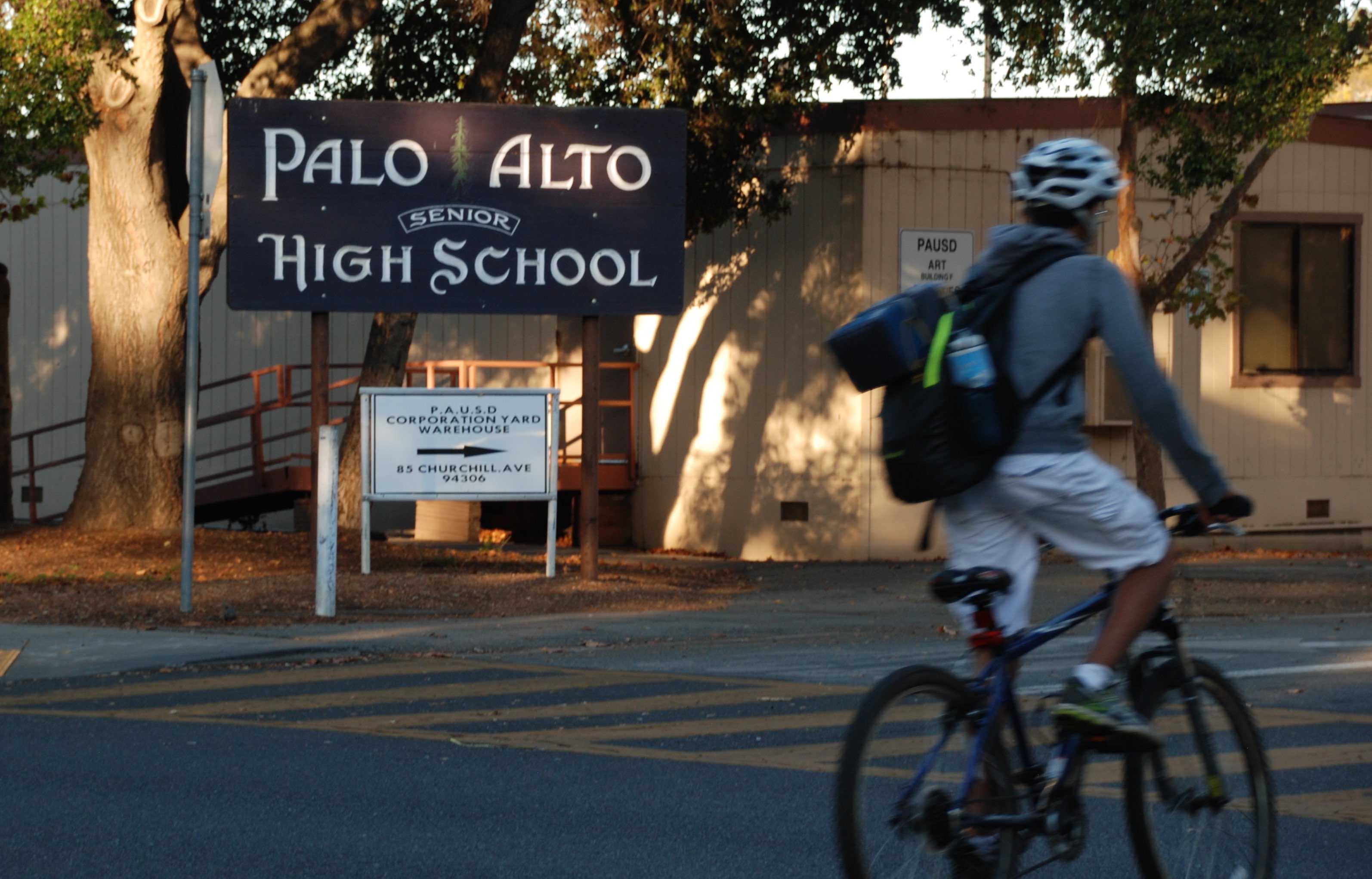 A Palo Alto High School student bikes past the Paly sign located at the intersection of Churchill Avenue and Castilleja Avenue before school. The school sign, one that does not have legal trademark according to Assistant Principal Jerry Berkson, was featured on a flyer .. “I think what he [the organizer of the event] did was deceptive in nature and I didn’t like it,” Assistant Principal Vicki Kim said. Photo by Jeanette Wong.