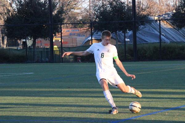 Junior center defender Neil Verwillow passes the ball upline. The Vikings continue undefeated in their season in league and overall. Photo by Emma van der Veen.