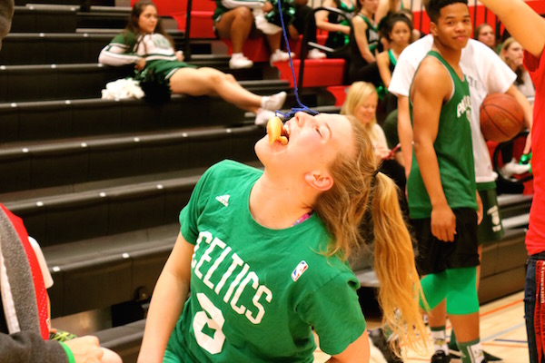 Junior Skylar Burris attempts to eat a donut in the obstacle course competition as part of the Paly upperclassmen team. Photo by Emma van der Veen.