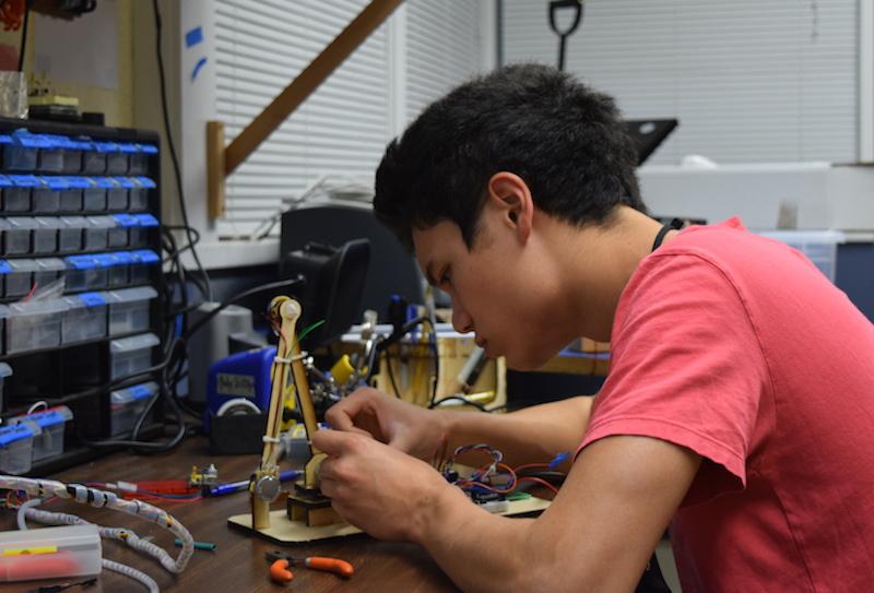 Senior Nathan Kau works on his robotic arm in preparation for the Santa Clara County regional tournament for Science Olympiad this weekend. The Palo Alto High School Science Olympiad team needs to place in the top four in order to advance to the state competition. Photo by Chirag Akella.