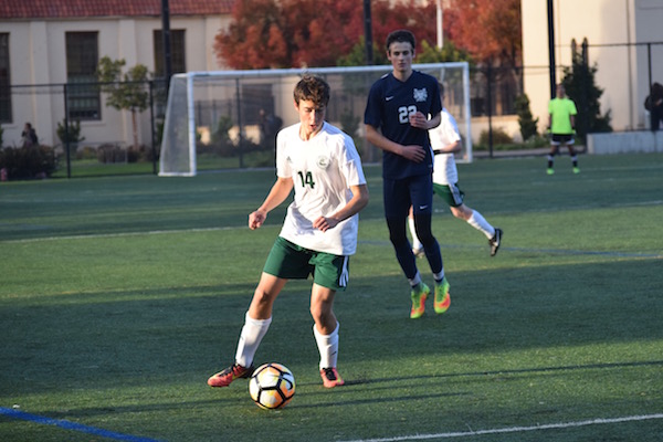 Sophomore outside midfielder Jason Shorin dribbles up the sideline. Shorin is a first-year Varisty player on the boys' soccer team. Photo: Emma van der Veen.