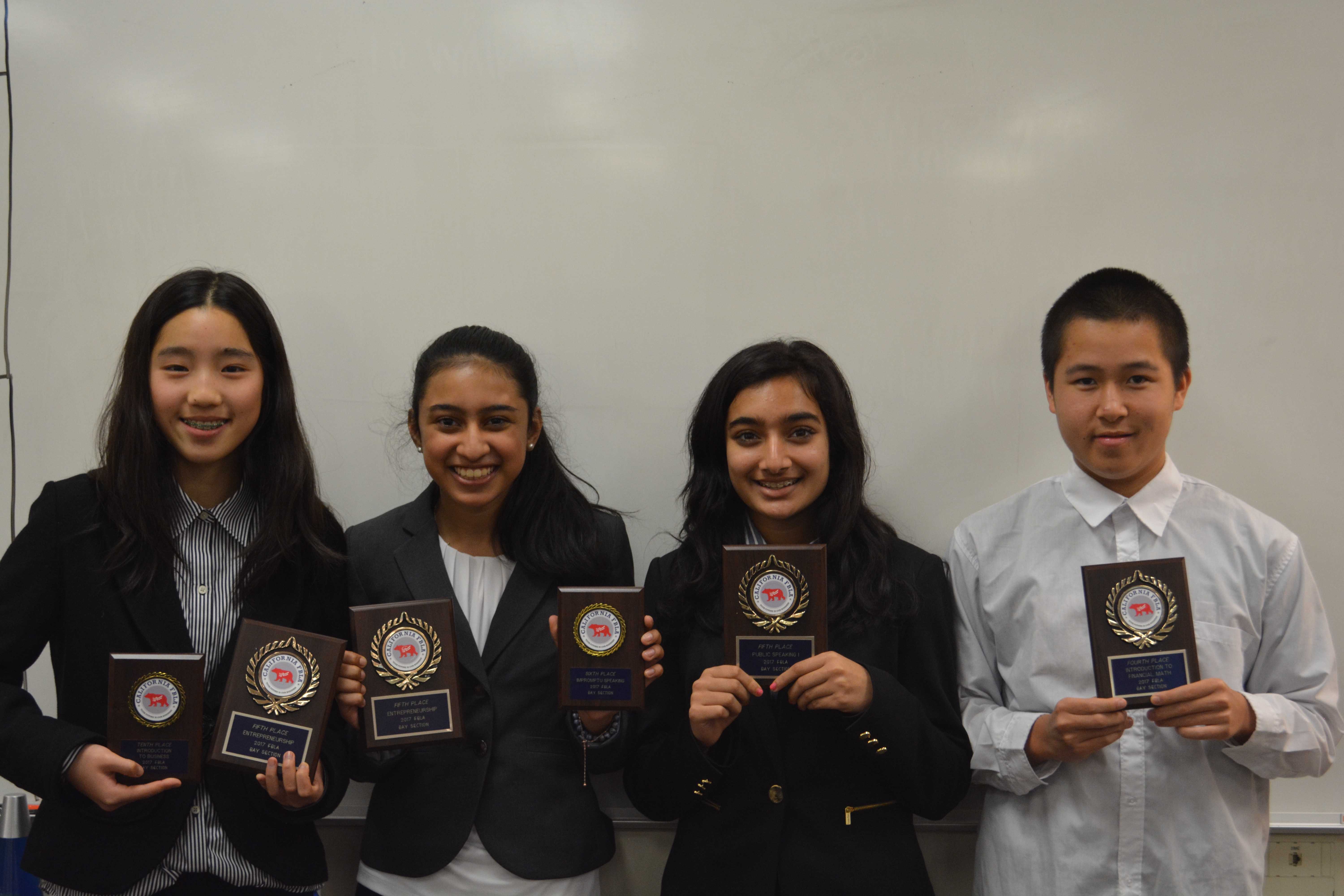 Left to right: Emily Wang, Ria Vora, Soumya Jhaveri and Leyton Ho pose with their plaques after placing at different conference events. Caity Berry, not pictured, also placed at the conference. Wang, Vora, and Ho will be competing at an upcoming state conference.