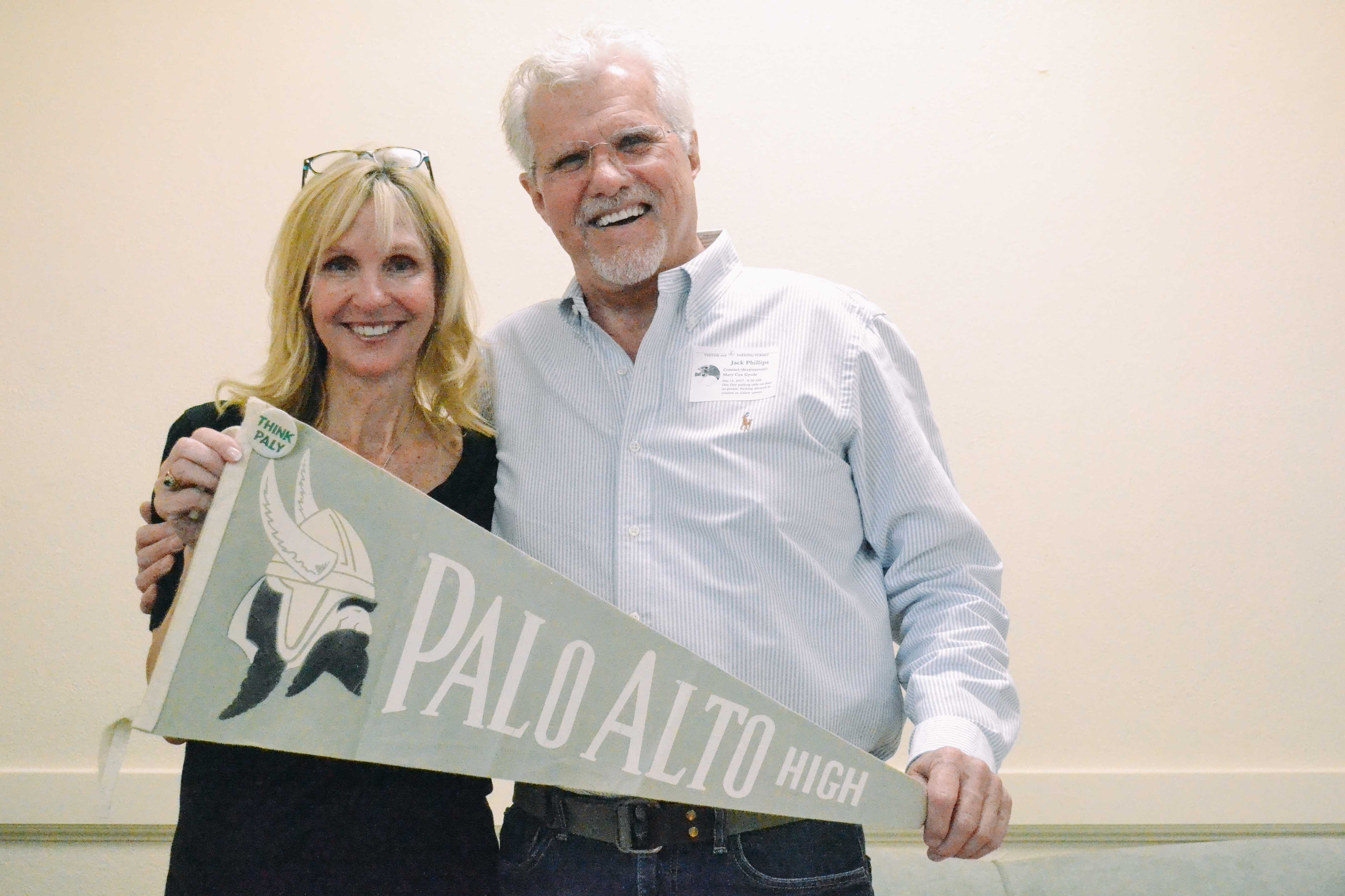 Meredith Gyves and Jack Phillips hold up a flag from Gyves' time as a student at Palo Alto High School. Gyves attended from 1966-69, and had Phillips as her English teacher senior year, before returning as the Work Experience teacher. "Once a Viking, always a Viking," Gyves said. Photo: Angelina Wang.