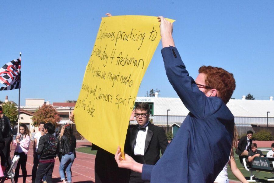 During Spirit Week Day Four, sophomore Benjamin Rapperport holds up sign with cheer on it. Sophomores in the stands chant for their participants in the games. Photo by: Nisha Mcnealis