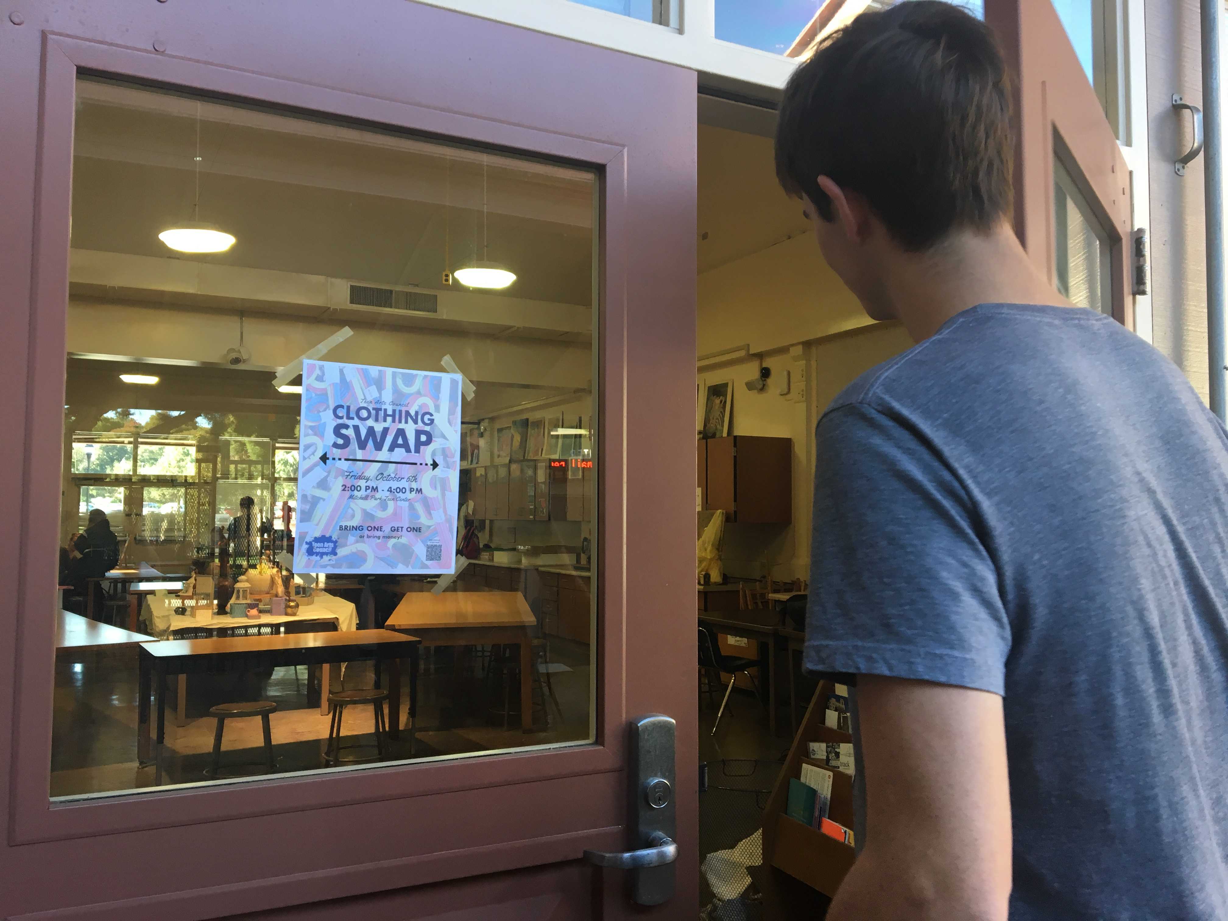 A student walks into the painting and drawing classroom, admiring the Teen Arts Council clothing swap flier. Photo: Leila Chabane