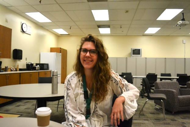 English teacher Lizzie DeKraai poses with her coffee in the English offices. Photo by Leila Chabane. 