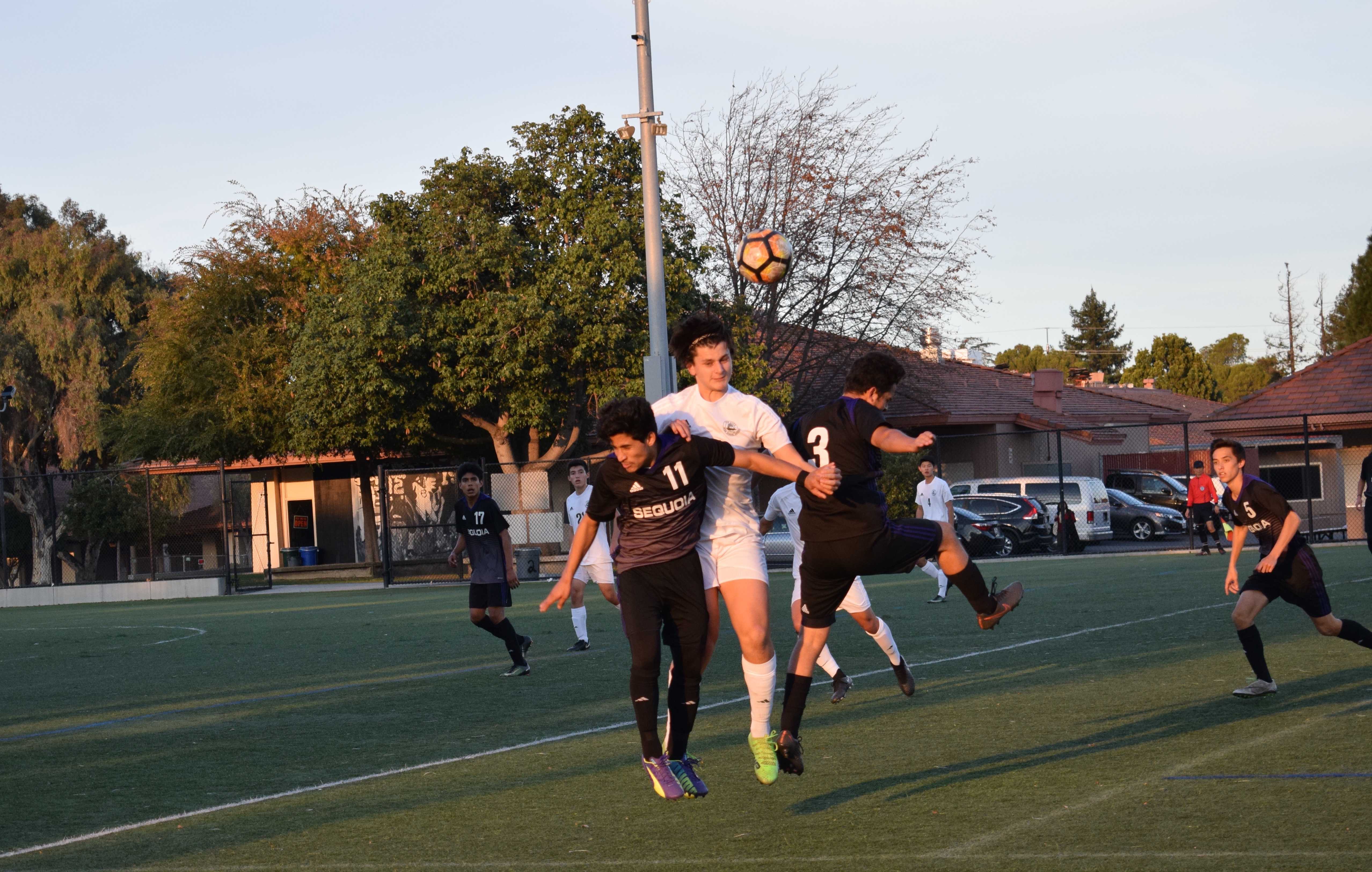 Senior Victor Magnussen heads the ball while blocking a Sequoia player during a game against Sequoia High School resulting in a Paly possession. Photo: Ankita Amberkar