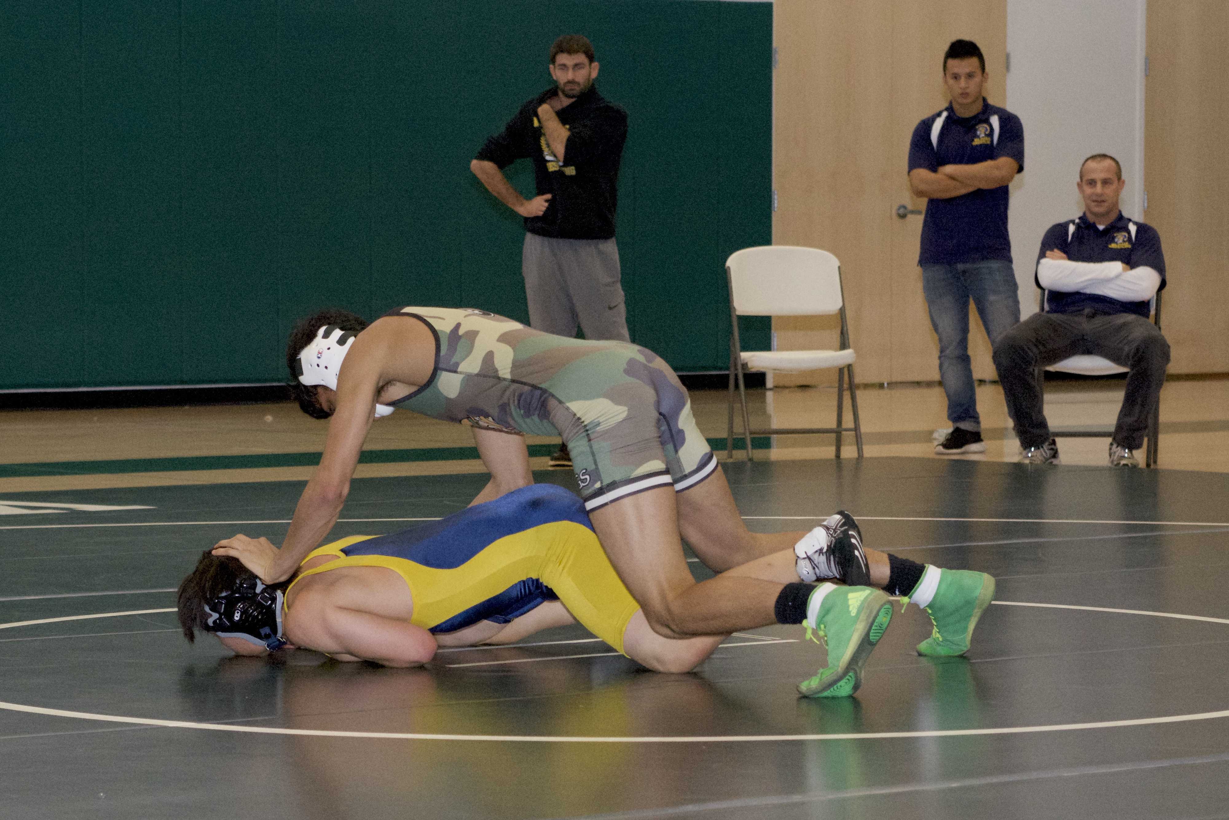 Palo Alto High School varsity wrestler Calvin Grewal takes down his opponent, winning by technical fall. The dual meet against Milpitas High School marked the first time the Vikings competed in the new Peery Family Center. "Coming off our loss last week, we were motivated and trained hard all week," Grewal said. "It was great to win our first home dual [meet] in the new gym in front of our crowd." Photo: Finn Mennuti.