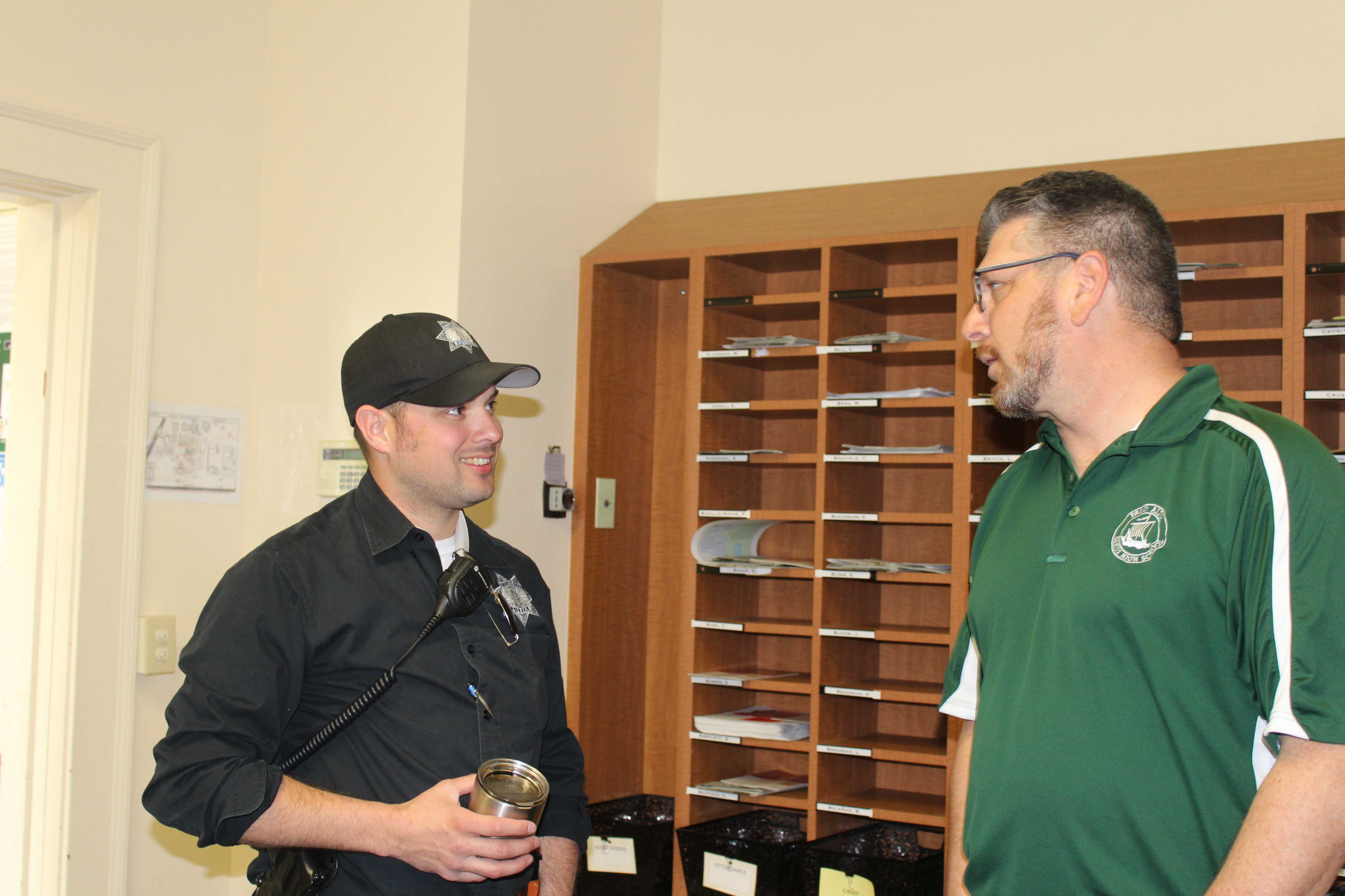 Assistant Principal Jerry Berkson speaks with one of the patrolling officers in the main office. Following the lockdown, the Paly administration and the Palo Alto Police Department are working together to find the person that made the threatening phone call to Paly. "Once the police gives us information, we will give the information out to the campus," Interim Principal Frank Rodriguez said. 