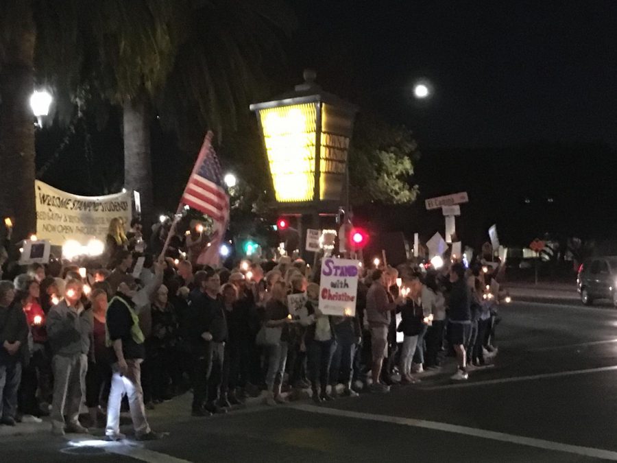 Activists wave the American flag alongside posters saying Stand with Christine at the corner of Embarcadero and El Camino. Members of the Palo Alto community organized a candlelight vigil Thursday night to show support for Christine Blasey Ford, who accused judge Brett Kavanaugh of sexual assault. I believe Christine Ford, attendee James Sheridan said. Shes part of my community.