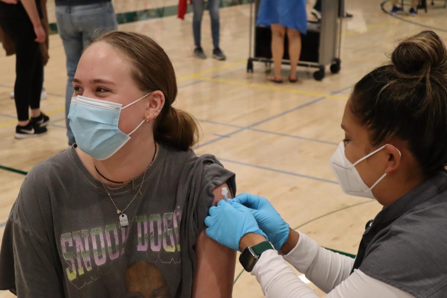 Jessica Haight, a freshman at Palo Alto High School, receives the vaccine at the clinic hosted at Paly's Peery Family Center gym.