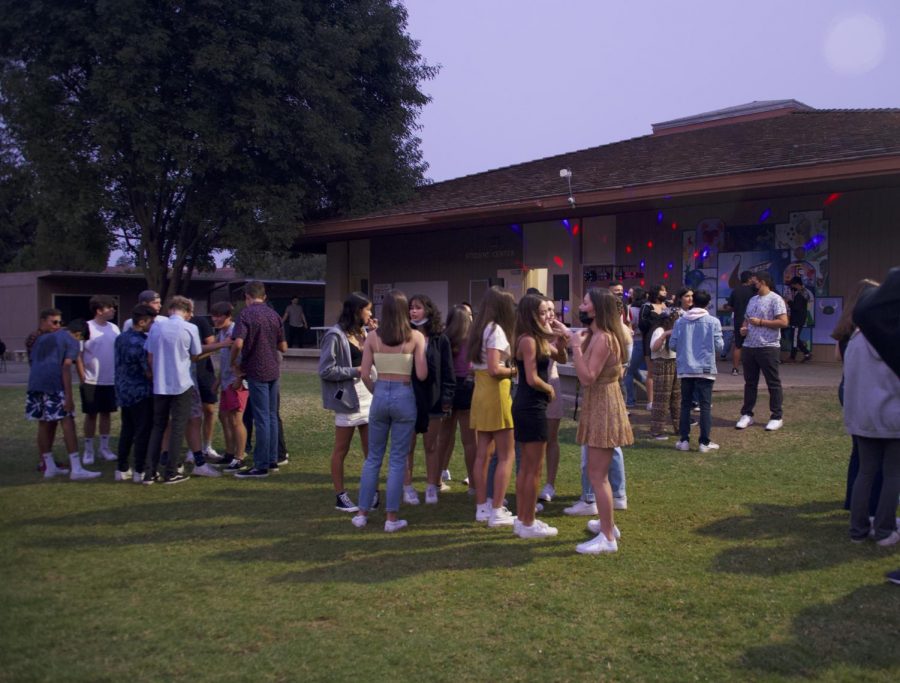 Students meet Friday evening on the Quad at Palo Alto High School’s Welcome Back dance.  “I’ve been looking forward to going with my friends and it seems really fun, the energy is really nice,” sophomore Lucy Li said. (Photo: Jonathan Chen)