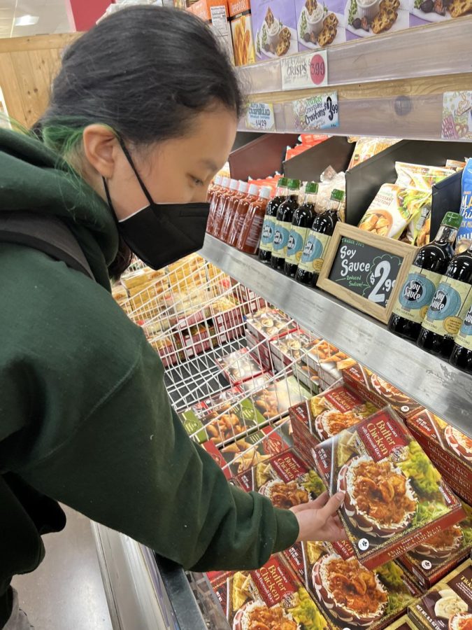 Sophomore Samantha Mann examines the prices of baked goods at Trader Joes before picking one out to buy. Trader Joes is among the many places at Town & Country to raise prices due to inflation, and students are noticing the price jumps. According to senior Ashley Qiu, the increased prices have made her more mindful of spending money. The increased prices have definitely caused me to now question my purchases twice before buying something, Qiu said. (Photo: Anna Feng).