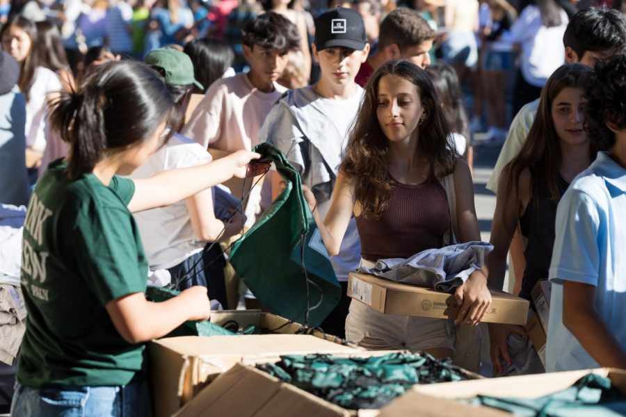 Link Crew member and junior class president Sophia Kim hands out Palo Alto High School merchandise to incoming freshmen as a part of Orientation day hosted Tuesday at Palo Alto High School. Freshmen were given tours of campus by members of the Link Crew and participated in various activities held by ASB, including a Pizza dinner and games. Additionally, students received their photo IDs and Chromebooks in preparation for the school year. ASB president Ashley Meyer said she is extremely grateful for the efforts of the volunteers who helped set up the event. I was worried that people would sign up and forget about it over the summer, Meyer said. But people were really dedicated to making this day happen which was amazing. (Photo: Daniel Garepis-Holland)