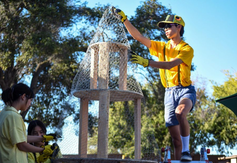 Junior Charlie Chen puts chicken wire to the top of a structure for their class’ Minions-themed float. Associated Student Body director Steven Gallagher said he thinks float building is a great way for students to bond. “​​Everyone from every class group gets together and tries to help out and put the wall up, so its definitely big community building,” Gallagher said. (Photo: Jonathan Chen)