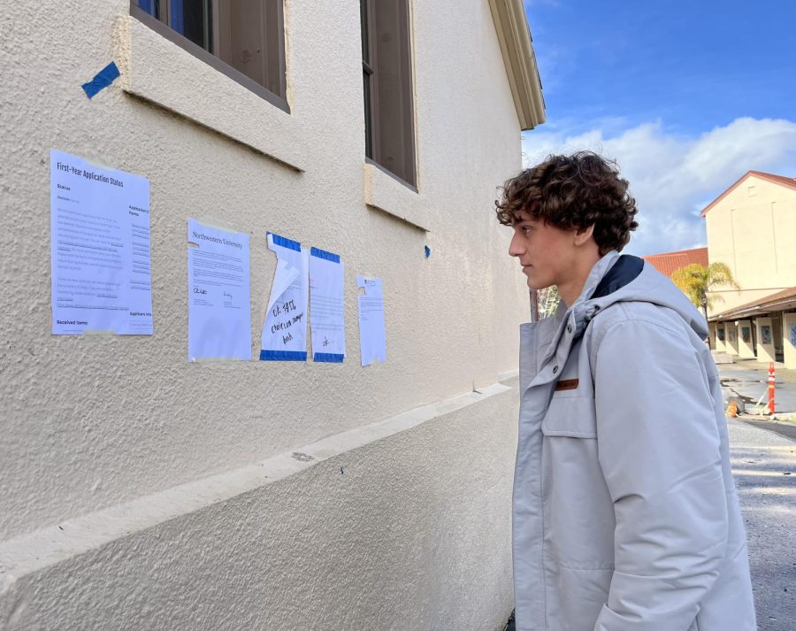 Senior Felix Blanch looks at the Wall of Redirection after school on the side of the Haymarket Theatre. Following a compromise between Palo Alto High School administration and the Associated Student Body, the formerly named the Wall of Rejection was rebranded to endorse positivity and to encourage opportunities that can arise from rejection, according to Principal Brent Kline. According to ASB senior class president Ashley Hung, no matter the name, the wall is meant to embrace rejection and endure it together. “We’re probably all going to be rejected by colleges, and the wall serves as a message that rejection is normal and human,” Hung said. “It brings our class together through shared experiences and helps create a culture that although what we’re going through can be difficult in the moment, we’re all in this together.” (Photo: Leena Hussein)
