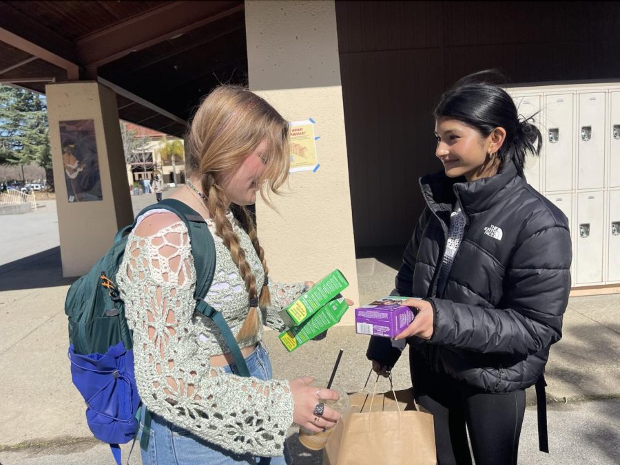 Junior Rori Escudero buys Girl Scout cookies from junior Anushka Junnakar during brunch, Friday, at Palo Alto High School. According to a New York Times article, prices for Girl Scout cookies are at an all time high. A box of core Girl Scout cookies flavors increased from $5 to $6 a box, with unauthorized platforms selling boxes online for more than 6 times the original price. However, Paly students are still excited to purchase their favorite cookie flavors. According to Junnakar, balancing cookie orders is difficult yet rewarding. “It’s a bit stressful during cookie season because I need to manage all of my online and in person orders,” Junnakar said. “I [also] need to estimate the right amount of each cookie to order from the warehouse. However, I think cookie season is fun because people are so happy when I deliver their cookies.” (Photo: Celina Lee)
