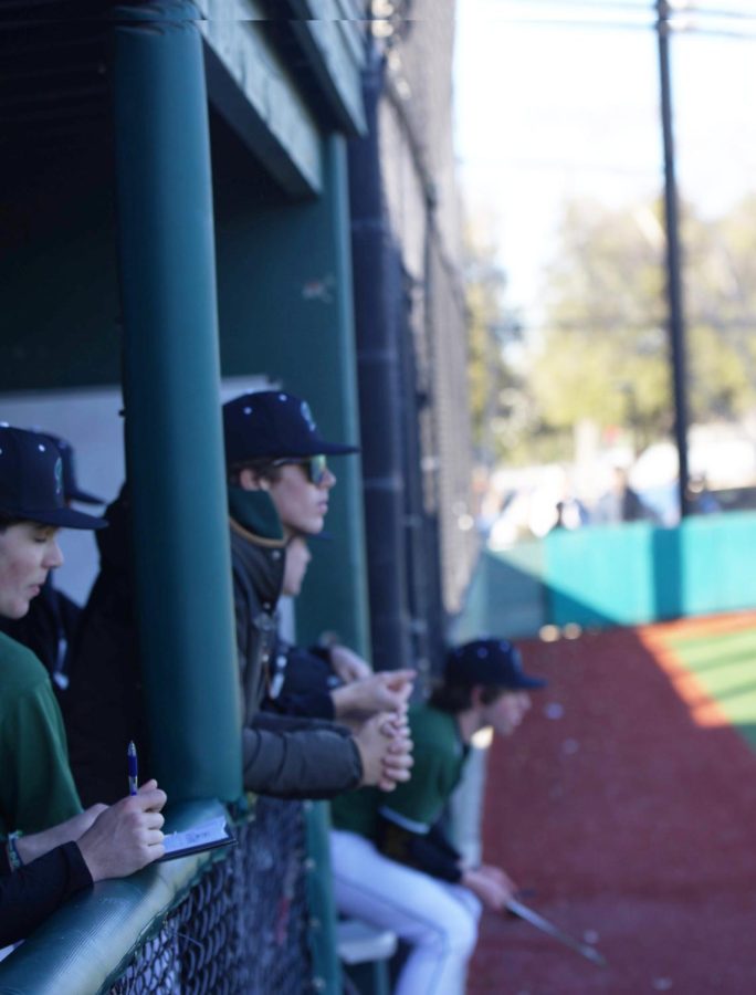 Sophomore Cormac White watches the baseball team take on Monterey from the dugout during the Mar. 1st home game. White made the Palo Alto High School varsity baseball team but is ineligible to play because of the California Interscholastic Federation Transfer Eligibility Guidelines. “Rules are rules, and I get it,” White said. “Obviously I’m really disappointed, but theres nothing I can do to change them.” (Photo: Shreyas Shashi)