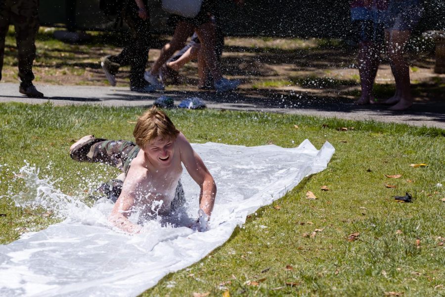 Senior Cameron Phillips splashes on a makeshift Slip N Slide set up during lunch yesterday on Palo Alto High Schools Quad. This watery fun was part of Field Day, a carnival-themed event hosted by the Associated Student Body, and also offered free desserts and game booths. According to senior Phela Durosinmi, Field Day was an enjoyable way to spend a sunny day. Its fun, because I just finished my last final, and theyre giving out free ice cream — everybody likes ice cream — and they let us have a slip n slide, while last year they closed it down, Durosinmi said. (Photo: Daniel Garepis-Holland)
