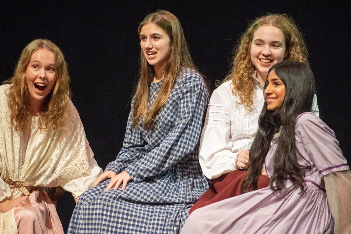 Dressed in historical clothing, Palo Alto High School seniors Sierra Rock, Zoe Hayward, Annalise Klenow, and sophomore Aashi Agarwal laugh with each other onstage during rehearsal for Paly Theatre’s “Little Women: The Broadway Musical, with opening night taking place at 7 p.m. Saturday in the Haymarket Theater. According to Klenow, the musical is intended to be an intimate, small-scale performance, which draws the performers close together. “Its a really small cast, so its very tightly knit,” Klenow said. “We all have to rely on each other, so I think that makes us all do our part and keeps us accountable.” (Photo: Kristine Lin)
