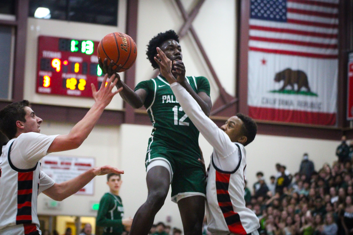 Palo Alto High School Viking junior small forward Jorell Clark attempts a layup while two Henry M. Gunn High School Titan defenders attempt to block the shot Saturday night during a crosstown rivalry match. The Vikings edged out the Titans, 62-57, in a game that nearly saw a comeback by the Titans in the fourth quarter. According to Vikings head coach Jeff LaMere, the team’s effort in their practices leading up to this game really showed in their performance. “Our guys really played hard,” LaMere said. “Hats off to Gunn [the Titans] because that was a great high school basketball game. They have very good players who can make tough shots.”