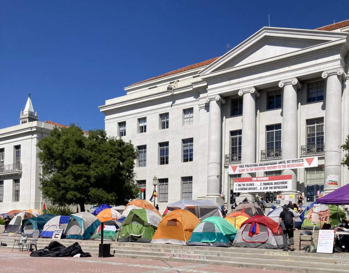 Student encampments protesting for the divestment of funds at the University of California, Berkeley (UC Berkeley). The banner spread across the building calls for a Free Palestine Encampment until UC Divests. Glory to the Martyrs, Victory to the Resistance! The second banner hung below outlines the protest demands: 1. End the Silence, 2. Financial Divestment, 3. Academic Boycott, and 4. Stop the Repression. 