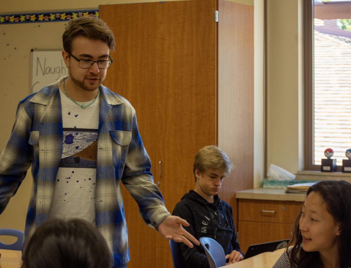 Alexander Dade discusses the math concepts behind their practice problems with his students in class last week at Palo Alto High School. According to Dade, his goal for the school year is to support his students as he kicks off his first year as a teacher. "I want to try out new ideas while also providing quality math education and really just figuring out what it is that I want to do as a teacher," Dade said. 