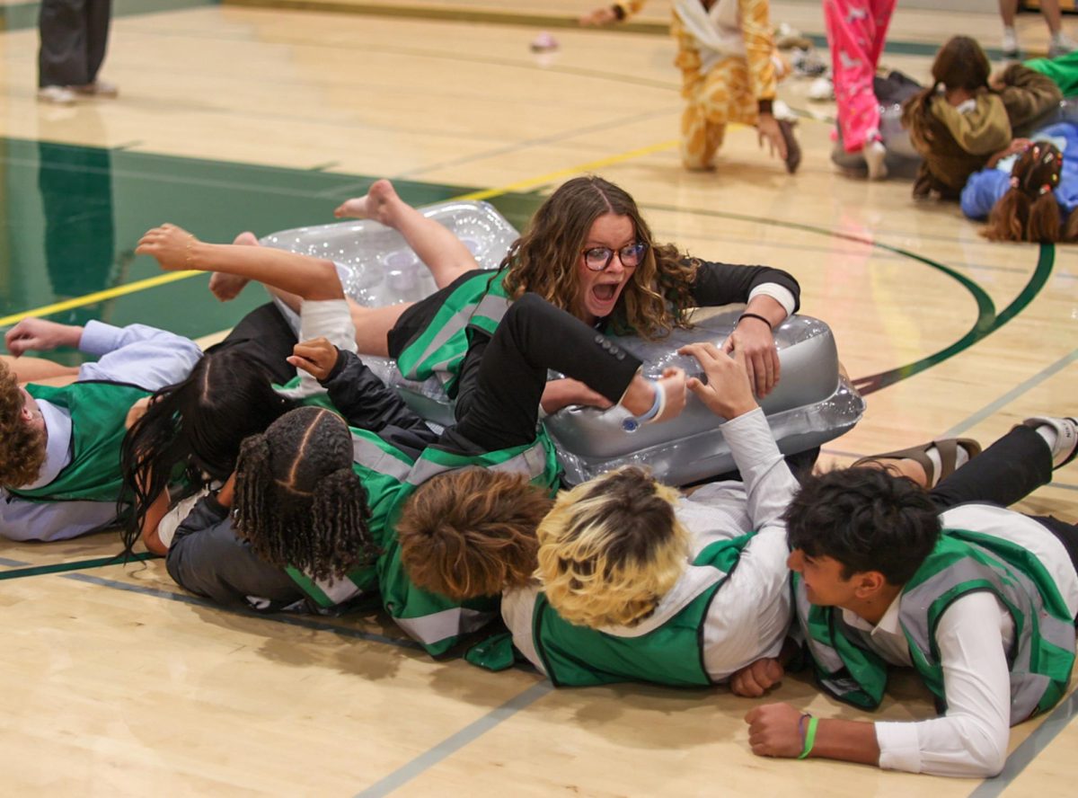 Junior Scarlett Frick sails across her peers during the Rapid River relay race. Senior Sophia Ahn, who attended the rally, found Spirit Week as a fun break from school. "It [Spirit Week] has been so fun," Ahn said. "I've loved seeing everyone dress up, I love taking pictures and it's a really nice break form all the stress."