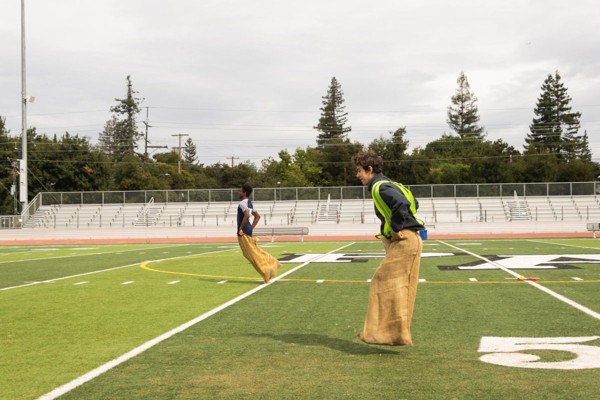 Junior Hadrien de Martel hops in a potato sack, racing the freshmen at the Spirit Week rally relay competition during lunch on Wednesday at Palo Alto High School's Earl Hansen Viking Stadium. According to freshman Maya Ratliff, dressing up for Spirit Week brightens up her day. "It just makes me a better person to see all these people dress up because I feel you're so cheerful and happy all the time and it's really positive," Ratliff said.