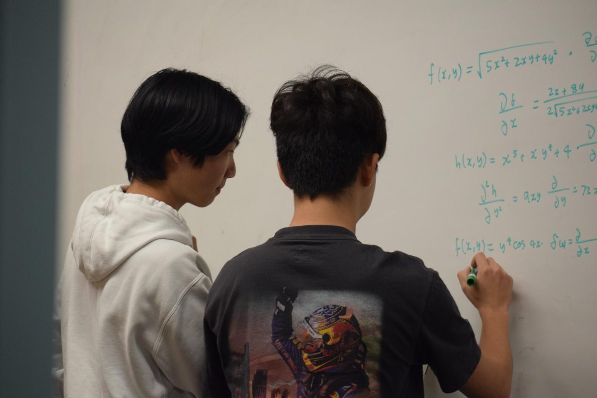 Senior Tony Chung and junior Jerry Yan work together on a math problem after school in the Palo Alto High School library.  According to math teacher and club advisor Randolph Mercado, after the competition the math team is now more motivated to improve. "The goal is to go to more competitions and do more math," Mercado said. "They're feeling good about it, but I think they're just happy to do math."