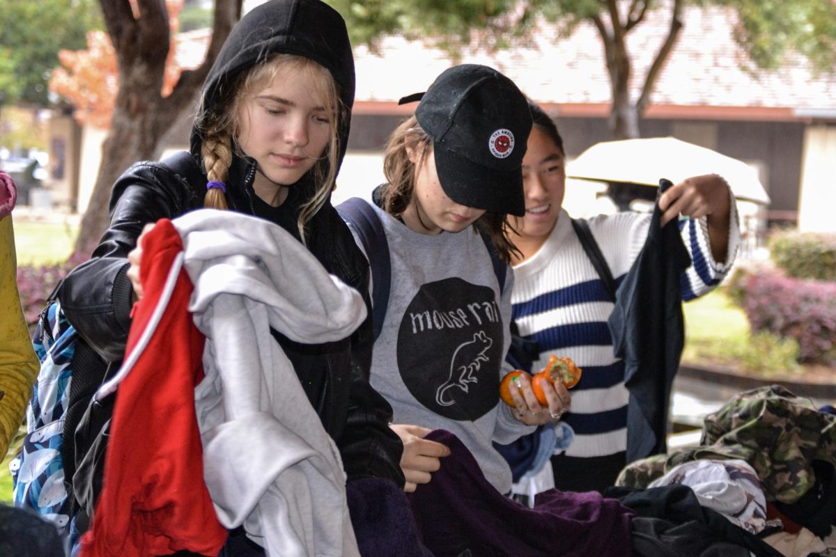 Students sift through piles of clothing at Palo Alto High School’s Thrift Fair during lunch on Friday near the library. According to sophomore Brennan Bailey, he appreciates the opportunity to find affordable clothes and explore different styles. “It positively influences people who maybe don’t have money for clothes, and can come try on stuff,” Bailey said.