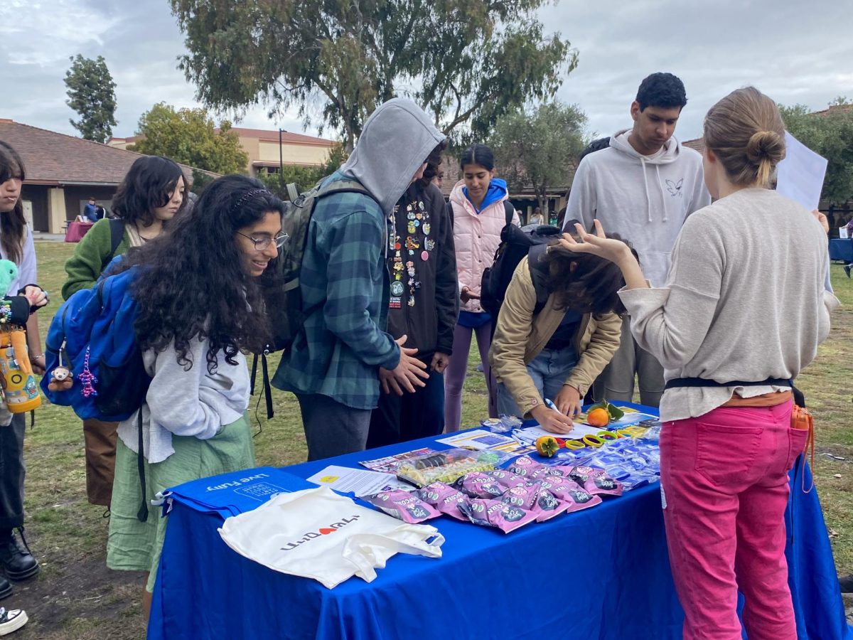 Students sign up for the mailing list at the Oshman Family Jewish Community Center's booth during Palo Alto High School's annual Service and Wellness Fair at lunch Wednesday on the Quad. According to sophomore co-president of the Paly YCS Club Tessa Berney, who helped coordinate the event, the fair provided a beneficial opportunity for both organizations and students. 
“One of their [the organizations’] main problems is that they can't really reach students, so this is a perfect way for them to communicate with Paly students and for Paly students to figure out how they can help the community,” Berney said. 