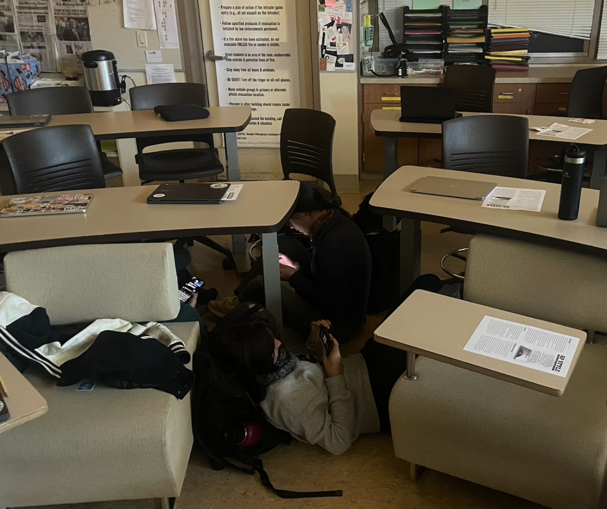 Students shelter beneath desks after a lockdown was issued at 11:24 a.m. for Palo Alto High School. According to Assistant Principal Jerry Berkson, a similar lockdown occurred at Gunn two minutes before the order to lockdown at Paly. “We got a call from a violence hotline that informed us that someone had mentioned in a chat that they were going to commit violence at our school,” Berkson said. 