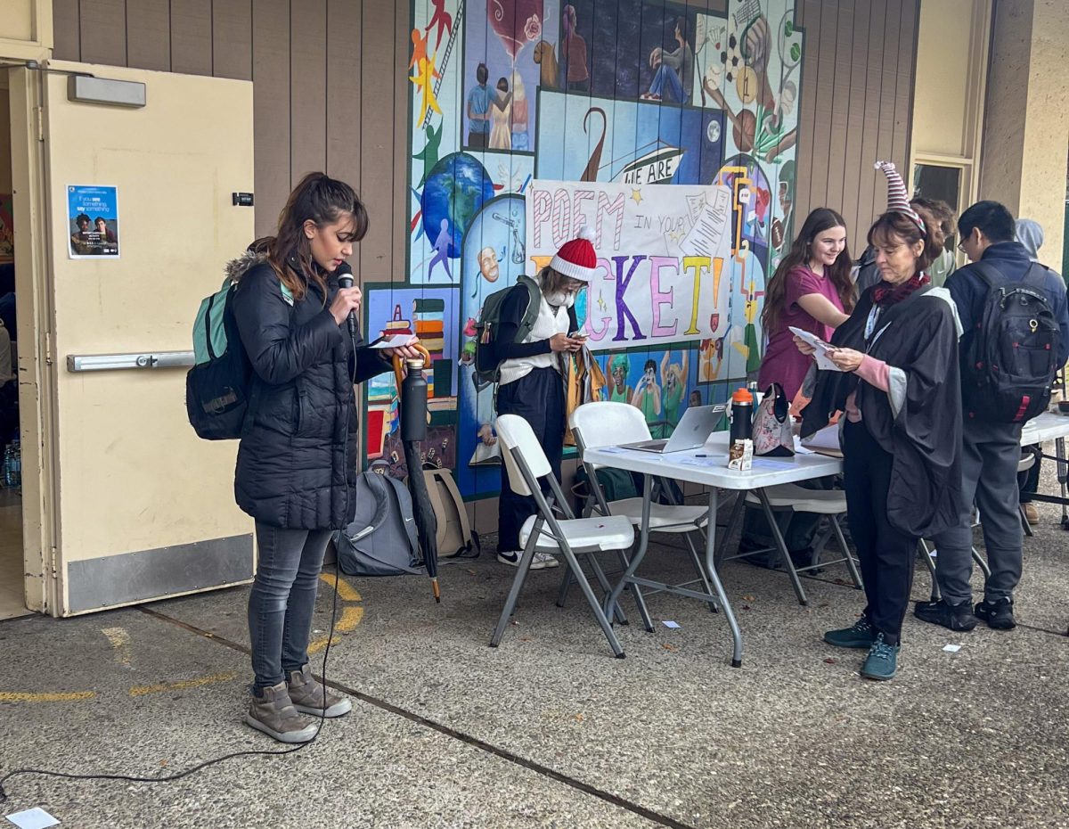 Students read aloud miniature poems during lunch last Thursday in front of Palo Alto High School's student center. According to Anna Van Valkenburg, a senior in Writer’s Craft, the poetry-reading event helps not only with their grades but also in bringing out different student voices. “I really like the idea of sharing poems,” Van Valkenburg said. “I also think it's a nice opportunity to boost your grade in the class and also get on the stage and read something. Ms. Filppu puts a big focus on amplifying voices that are not usually heard." (Photo courtesy of Brent Kline)