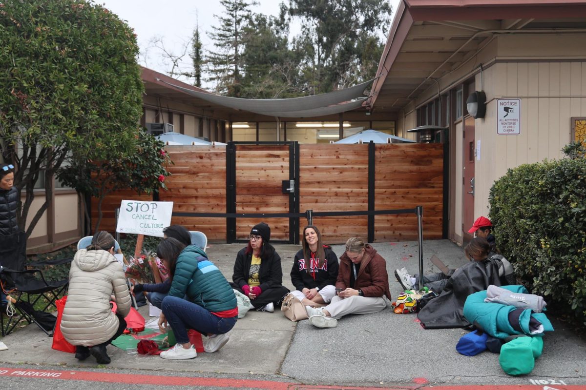 A small crowd gathers in front of Palo Alto Unified School District's boardroom, hours before the doors open for tonight's meeting. According to community member Sara Woodham, she is coming in support of Danae Reynolds, who was impacted by new board member Rowena Chiu’s recent online activity following the previous board meeting earlier this month. “The part that is truly concerning or worrisome is the use of social media to characterize that meeting and essentially re-tweeting a website that had all these flagrantly racist posts at the time of the reposting,” Woodham said. “It essentially led to Danae [Reynolds] getting even more threats and racist commentary. I also find it ironic because what spawned from the notion that Rowena felt unsafe is that Danae literally became unsafe, and it really became dangerous for her.”