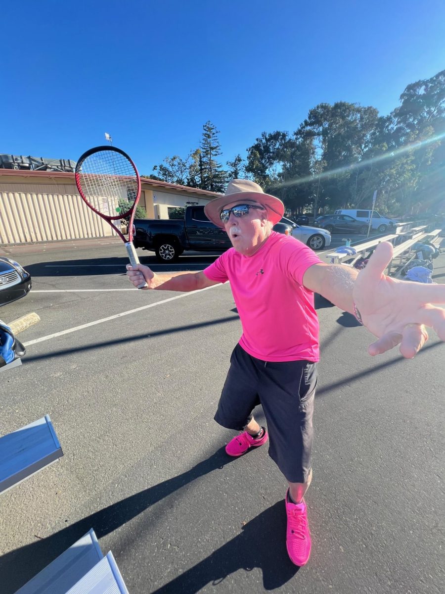 Former head coach Andy Harader poses with his pink spirited outfit outside the Palo Alto High School tennis courts. According to Harader, he is very proud of players implementing his advice. "To see players inspired and utilize techniques I drilled into them is very gratifying and has given me a sense of pride," Harader said.