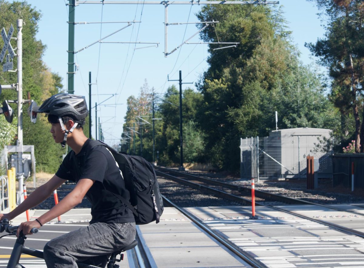 Sophomore Kyvan Chen bikes over the Churchill Avenue crossing at the end of the school day Tuesday. Dan Lieberman, public information officer for Caltrain, said RailSentry was installed at the Churchill Avenue and Alma Street crossing earlier this year. “It is a LiDAR (light detection and ranging) and camera-based AI solution that can identify when people, cars or objects are acting out of the ordinary, allowing Caltrain to alert trains and dispatch the Transit Police,” Lieberman said.